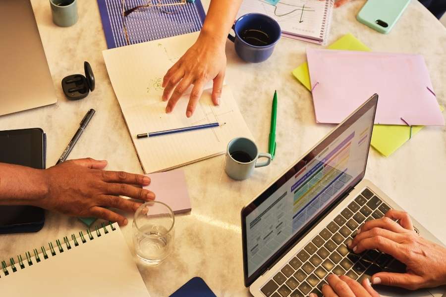 Une équipe collabore activement autour d'un bureau pour planifier et financer les projets de l'entreprise.